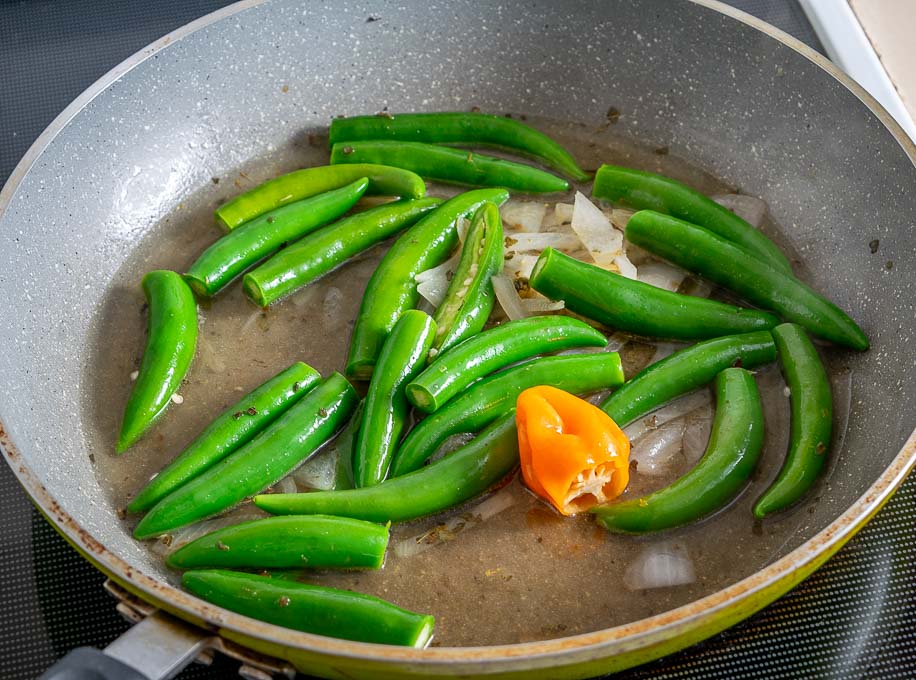 Adding Serranos and Habanero to the pan