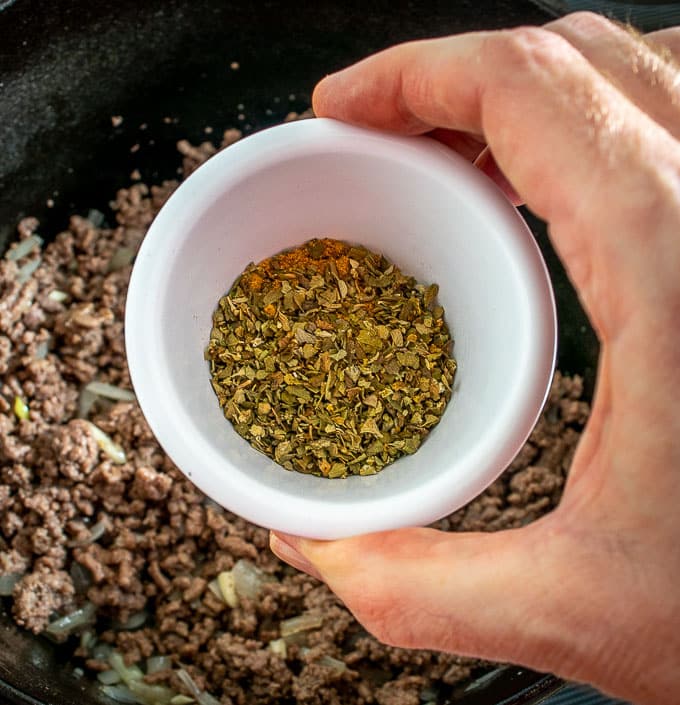 Adding Mexican oregano and cumin