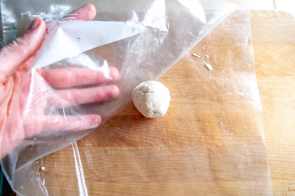 Surrounding dough ball with plastic