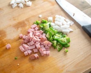 Chopping onion, jalapeno, ham for the Migas