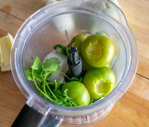 Adding salsa verde ingredients to a blender