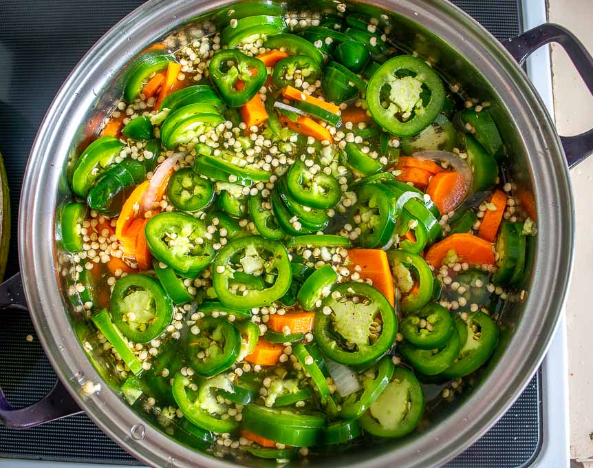 Adding sliced jalapenos to the saucepan