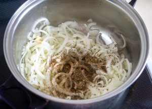 Adding crushed spices to the onions