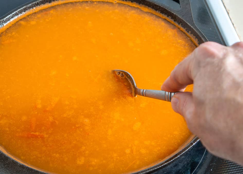 Adding stock and salt to the tomato onion garlic mixture