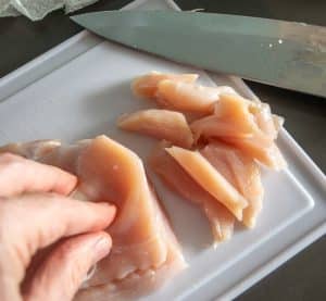 Chopping chicken into bite-sized pieces
