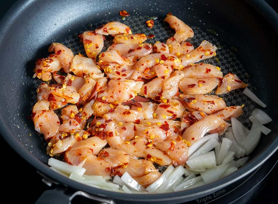 Adding the chicken to the pan and forming a single layer