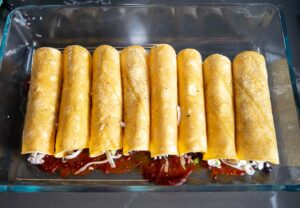 The enchiladas rolled up and pictured before baking
