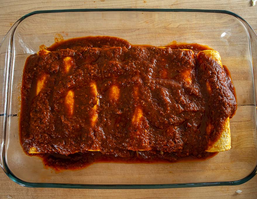 Adding sauce to top of enchiladas