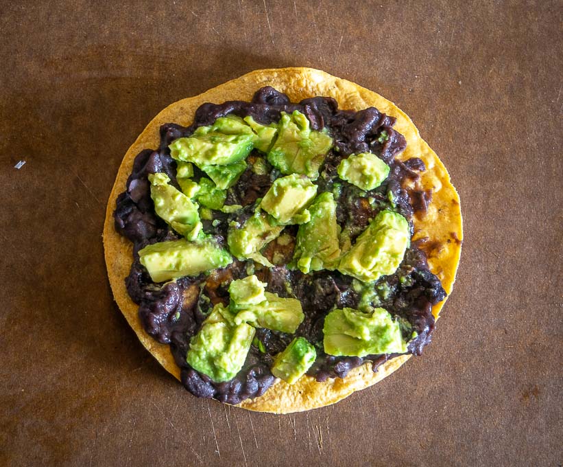 Adding avocado bits to the tostada