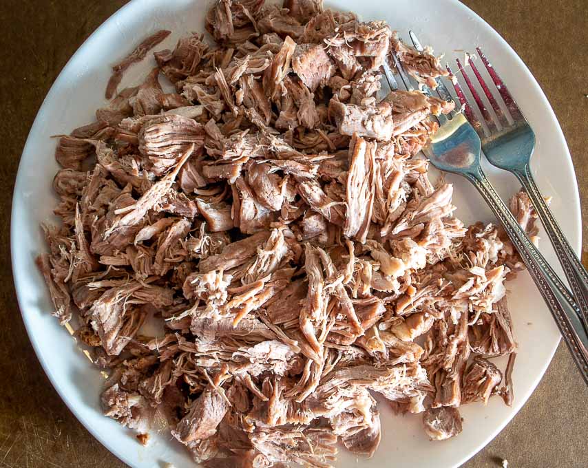 Shredding the boiled pork with two forks