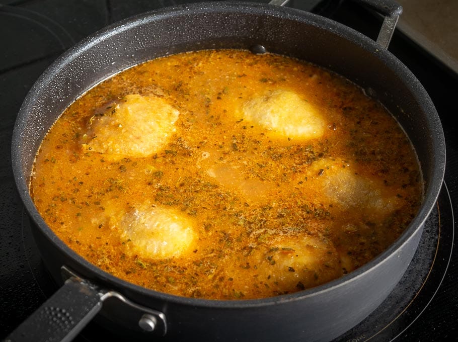 Adding chicken thighs to the pan right before cooking