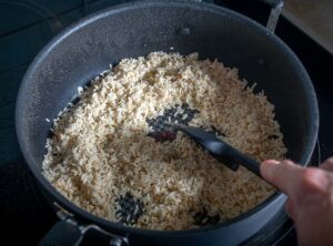 Cooking rice in the chicken juices for Arroz con Pollo
