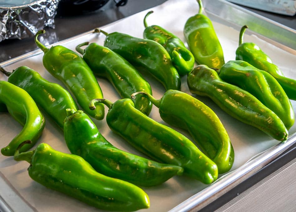 Adding 2.5 lbs. Hatch chiles to a baking sheet for roasting