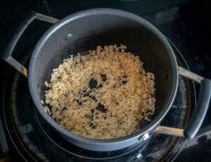 Saute the rice in some oil and fat from the chicken