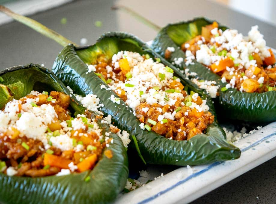 Adding cheese and cilantro to the stuffed Poblano chiles