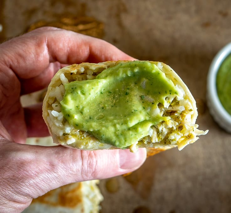 Adding a bit of Salsa de Aguacate to each bite of the burrito