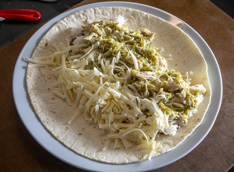 Adding rice and cheese to the Chicken Chile Verde Burritos