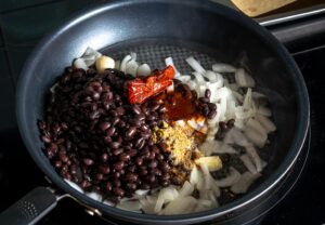 Adding the beans and chipotles to the pan