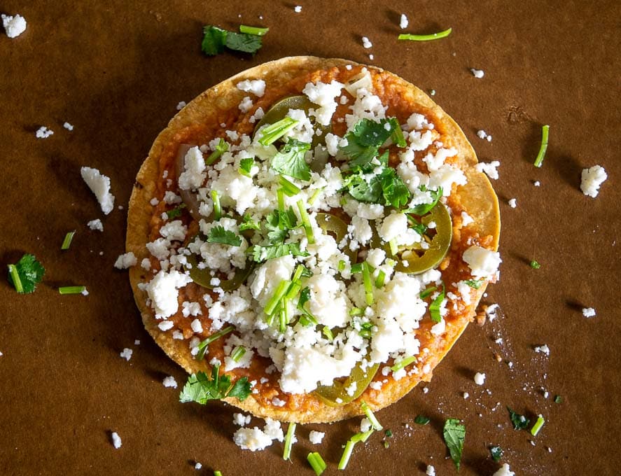 Adding Queso Fresco to the Charro Bean Tostadas