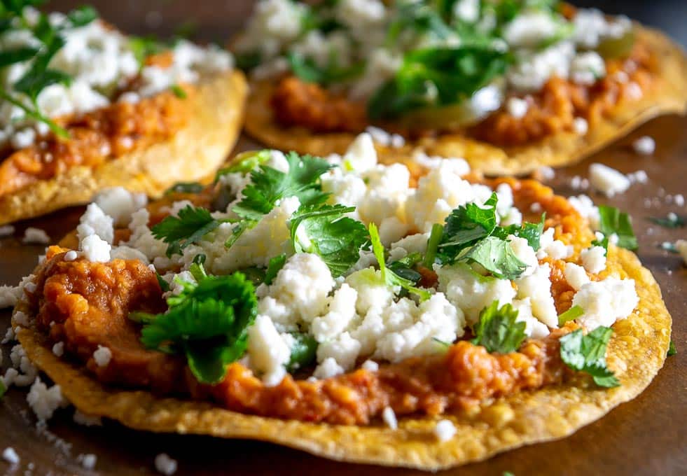 Loading up the Charro Bean Tostadas with cilantro and pickled jalapenos
