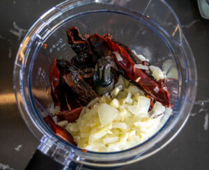 Adding the reconstituted chiles to the blender