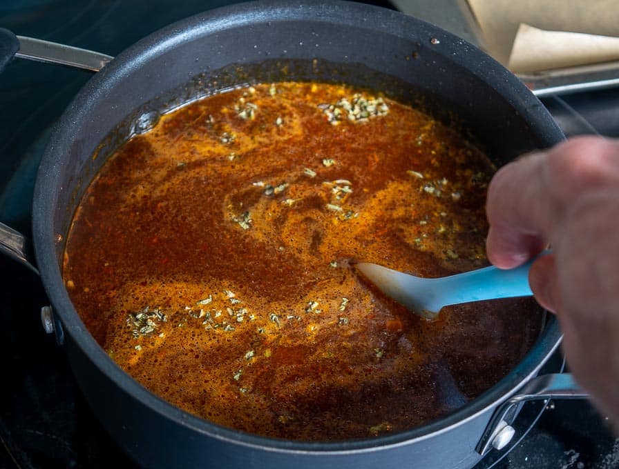 Adding the remaining ingredients to the Pozole