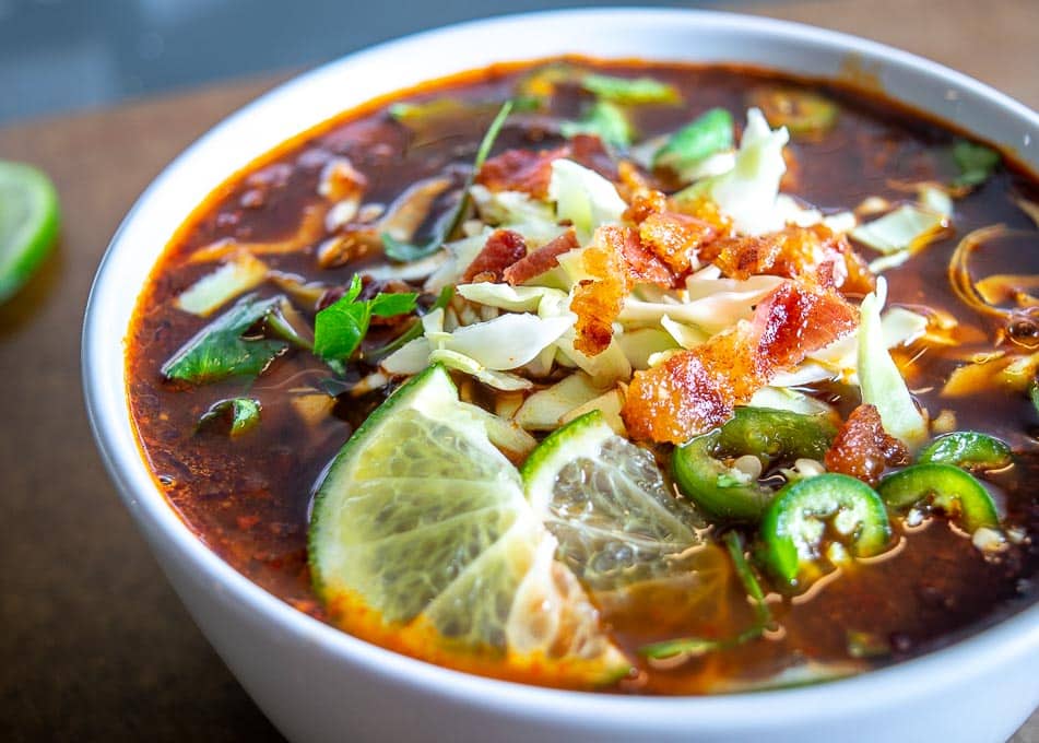 Adding cooked bacon as a final garnish for the Red Pozole