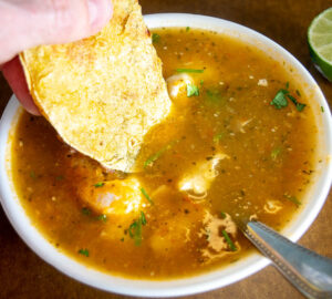 Dipping corn tortilla in the poached egg broth