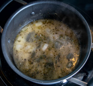 Adding the chopped Poblano to the soup pot