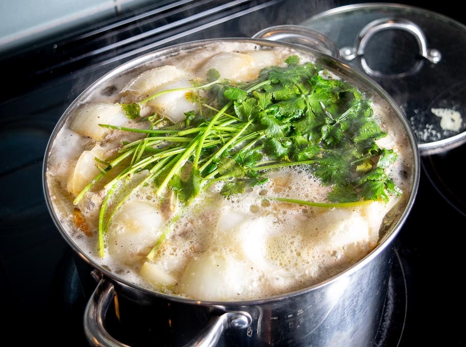 Foam rising to the surface as the chicken stock heats up