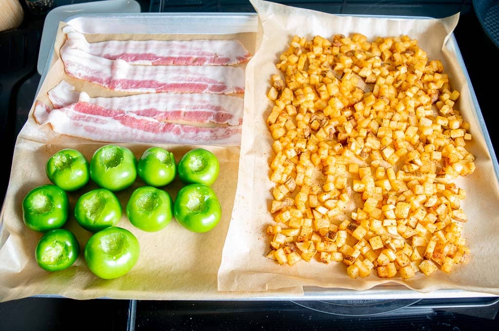 Adding bacon and tomatillos the baking sheet