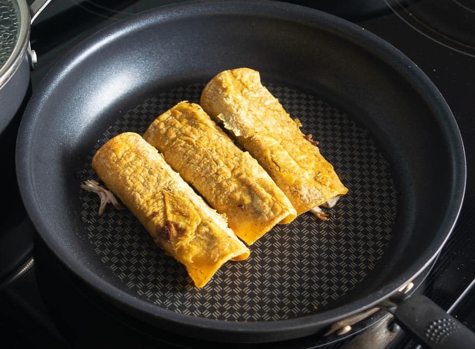 Cooking the enchiladas in the bacon drippings