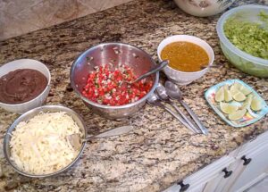 Bowls of fixings for the Chicken Taco Bar including guacamole