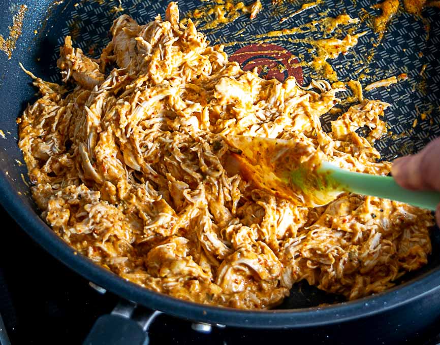 Adding the shredded chicken to the creamy chipotle sauce 