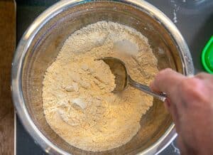 Combining flour, salt, and masa harina in a mixing bowl
