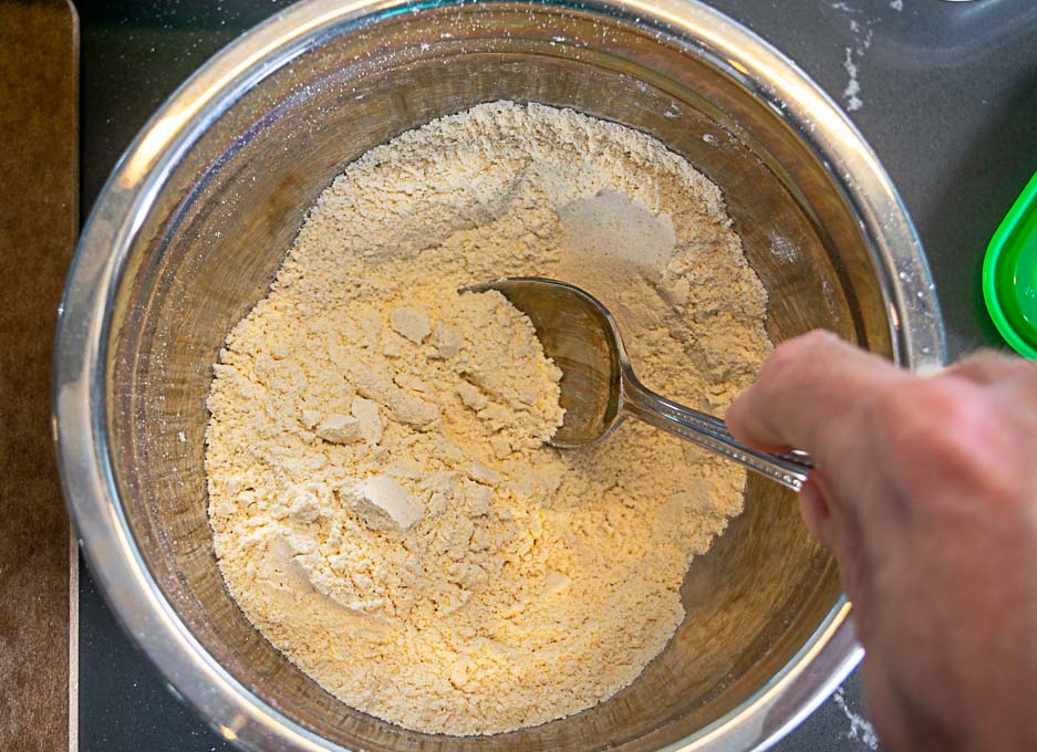 Combining flour, salt, and masa harina in a mixing bowl