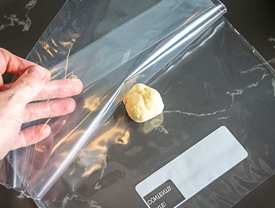 Surrounding the dough ball with a Ziploc bag