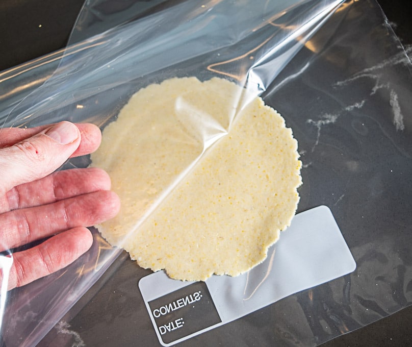 Peeling off the Ziploc bag from the flattened dough ball