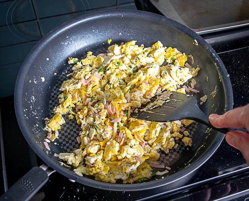 Adding diced up ham to the egg mixture