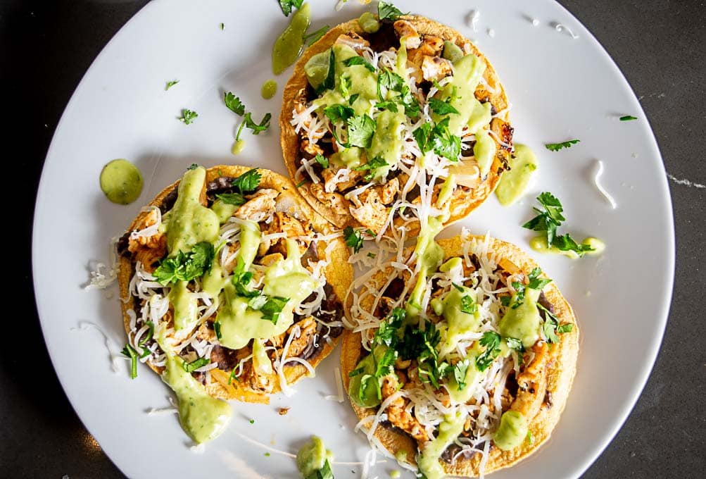 Chicken Tostadas after being topped with cheese and Salsa de Aguacate