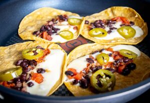 Building crispy tortillas with Jack cheese, pickled jalapenos, and some beans from the pot