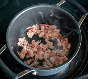Cooking two slices of bacon in the soup pot