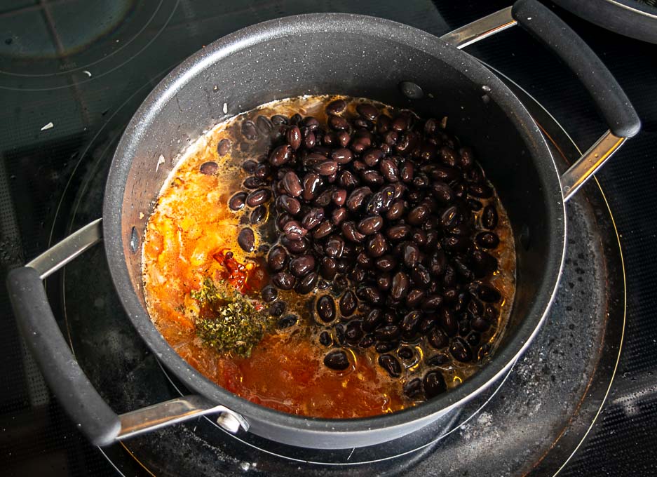 Adding the drained and rinsed beans to the pan