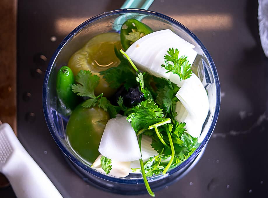 Adding all the avocado salsa verde ingredients to a blender