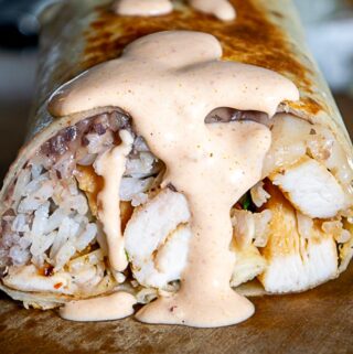Drenching the burritos with creamy chipotle sauce