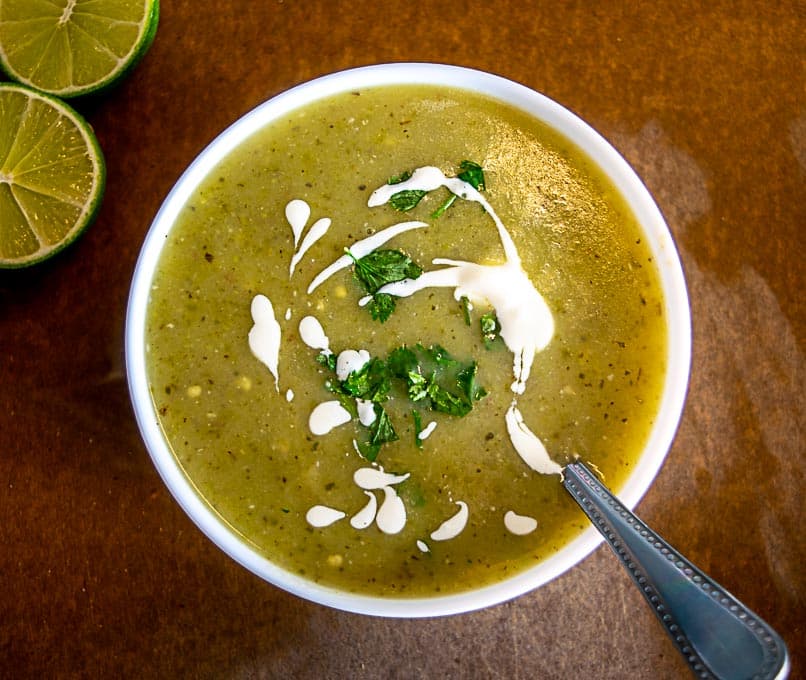 Garnishing the Roasted Jalapeno Soup with crema, cilantro, and a squeeze of lime