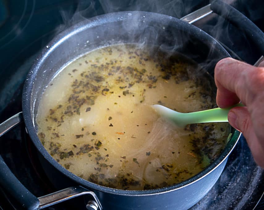 Adding Mexican oregano to the soup