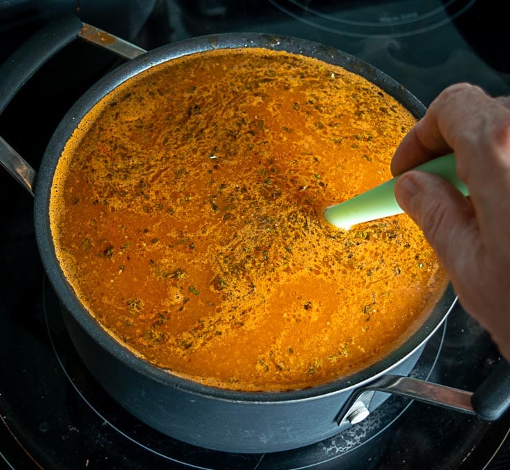 Adding the broth to the tomato onion garlic mixture