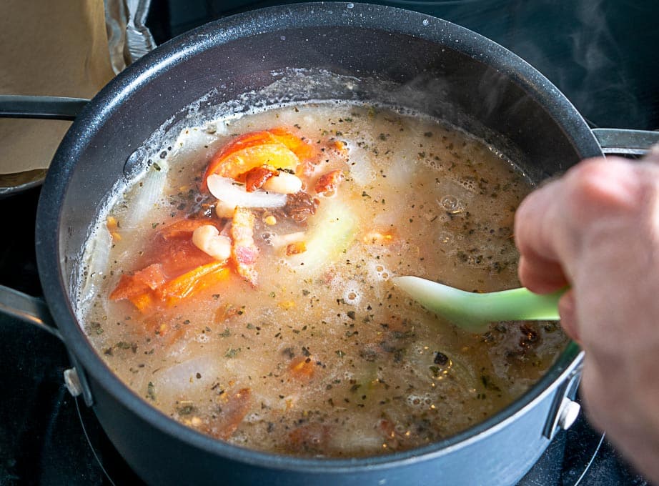 Adding stock and the chipotle to the soup