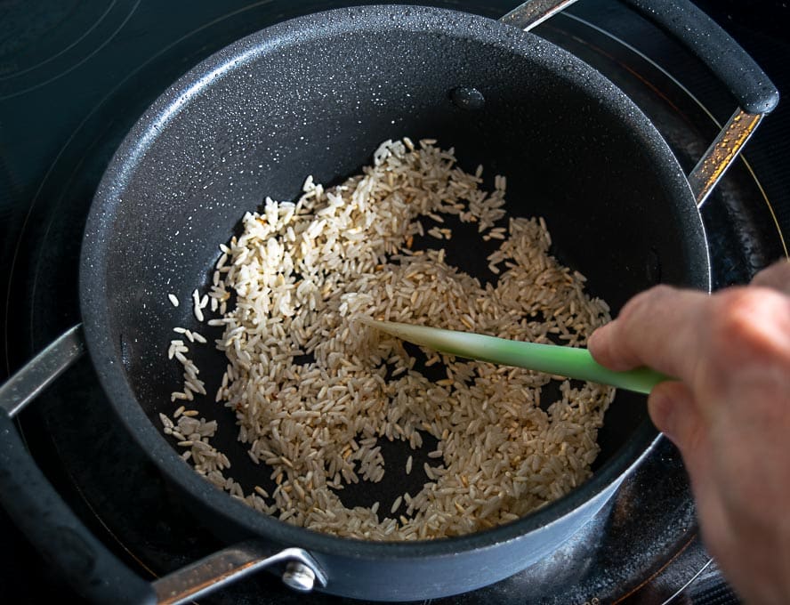 Cooking half cup of white rice in the same pan using some of the chicken fat